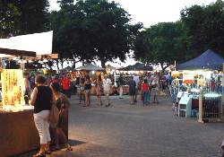 Market stalls are spread among the trees. Mindil Beach market stalls.